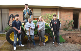 Photo of students with shovels in courtyard