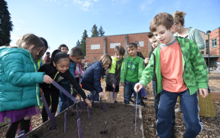 Students view the raised planter beds in their new garden at Washington Elementary