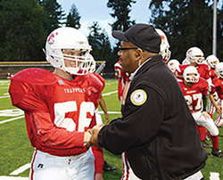 District resource officer shaking the hand of a Fort Vancouver High School football student.