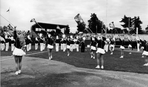 The Propstra Stadium, located on the Hudson's Bay High School campus, is dedicated. The band and color guards are performing on the field. George and Carolyn Propstra donated $1.1 million to build the stadium.