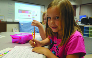 Jump Start student writing her letters in class