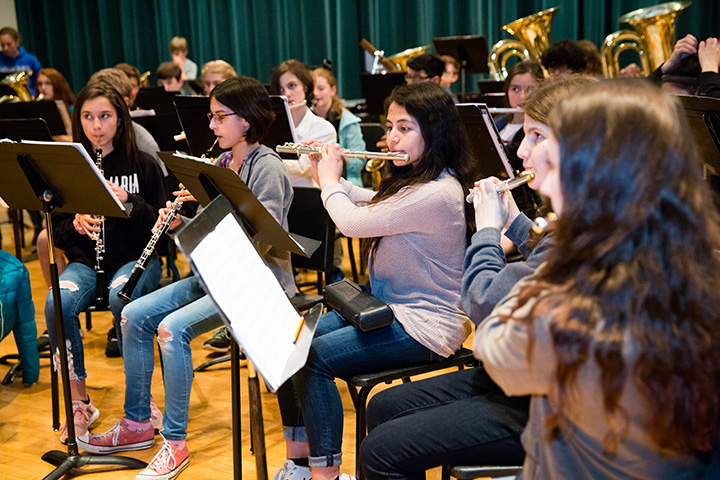 Middle school honor band students rehearse before a concert