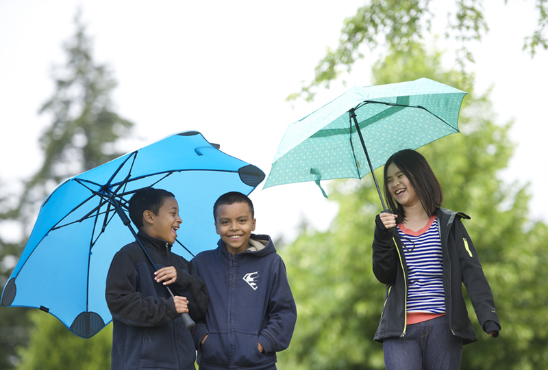 Students laughing in the rain with umbrellas. Pacific Northwest weather!