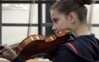 Student playing the violin in band class.