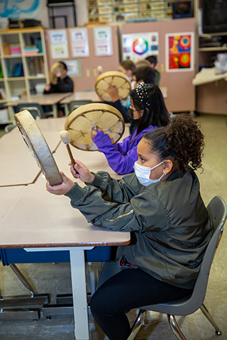 Students play hand drums