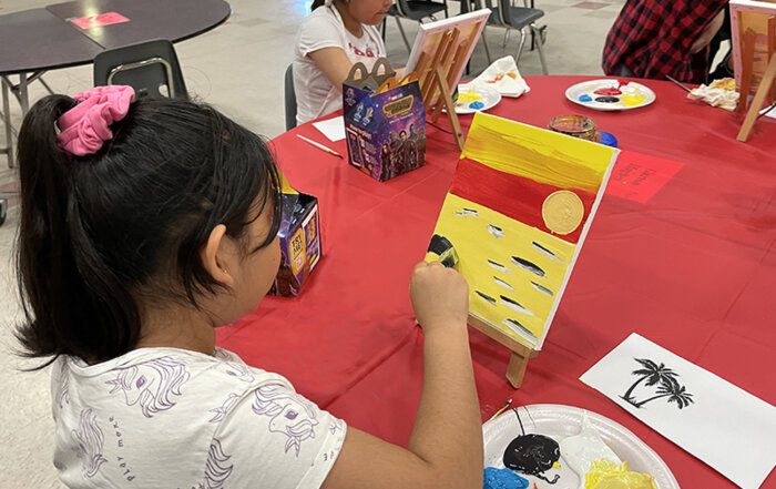 Students painting at La Plaza at Harney Elementary School